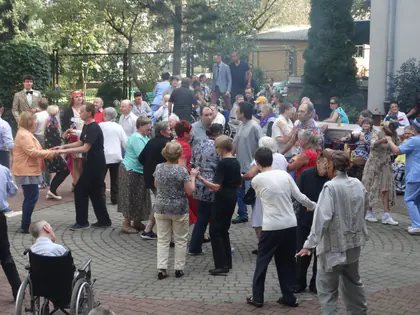 Tłum gości tańczy na podwórku podczas pikniku w stylu lat siedemdziesiątych