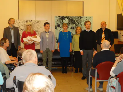 Aktorzy kabaretu stoją w szeregu przed widownią, część mieszkańców siedzi na wózkach
