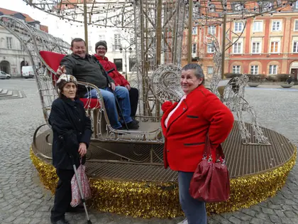 Mieszkańcy pozują przy świetlnej instalacji z ławką na Starym Mieście