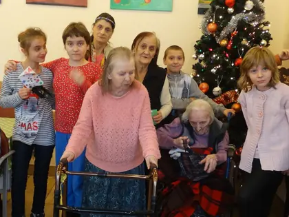 Dzieci i mieszkanki przy choince podczas warsztatów świątecznych