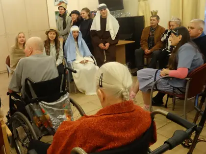 Młodzież w strojach jasełkowych występuje przed mieszkańcami siedzącymi na wózkach