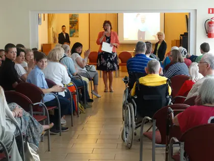 Prowadząca z mikrofonem stoi w przejściu między rzędami widzów na spektaklu