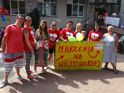 Wolontariusze i mieszkańcy trzymają transparent z napisem Marzenia na Wójtowskiej