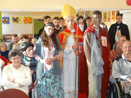Uczniowie w strojach świętych, w tym biskupa, wśród mieszkańców