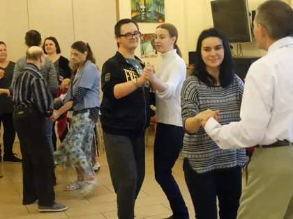 Mieszkańcy i goście tańczą w parach w świetlicy