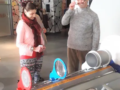Mieszkanka i mieszkaniec przy eksponacie z lusterkami w centrum nauki