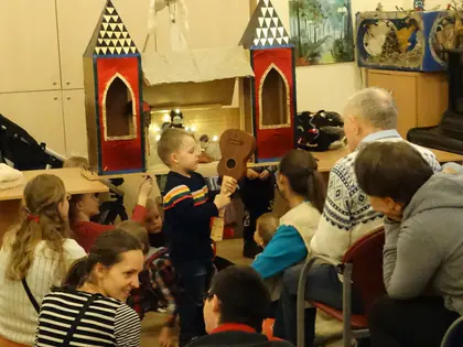 Dzieci z pacynkami przedstawiają szopkę przed mieszkańcami