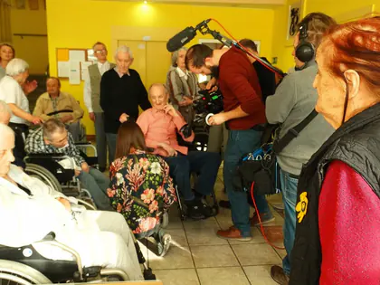 Ekipa filmowa z kamerą nagrywa mieszkańców w świetlicy