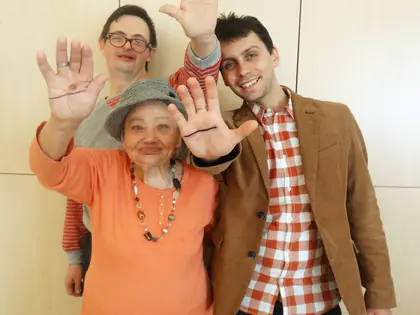 Mieszkanka i wolontariusze pokazują dłonie z narysowaną linią prostą