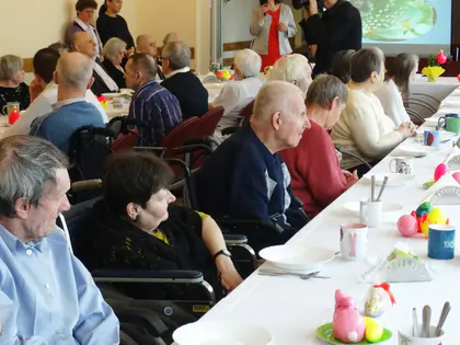 Mieszkańcy przy odświętnie nakrytych stołach na obiedzie wielkanocnym 2018