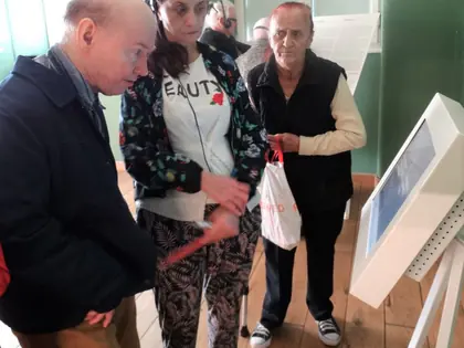 Uczestnicy wycieczki czytają informacje z tablicy w muzeum