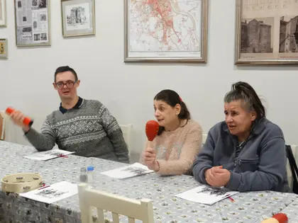 Troje mieszkańców przy stole gra na grzechotkach i marakasach