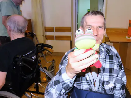 Mieszkaniec pokazuje pluszową zabawkę w kształcie żaby