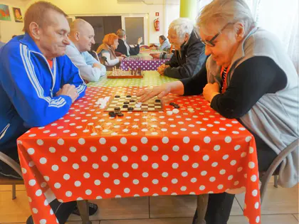 Mieszkańcy grają w warcaby przy stole w czerwone grochy