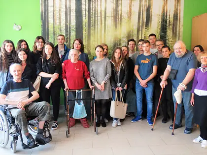 Uczniowie i mieszkańcy pozują przed fototapetą z lasem