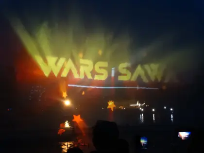 Laserowy napis Wars i Sawa nad wodą podczas nocnego pokazu