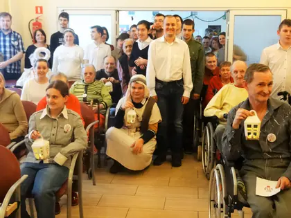 Mieszkańcy i młodzież pozują w świetlicy z lampionami