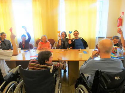 Mieszkańcy unoszą do góry papierowe serca