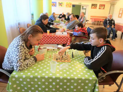Chłopiec gra w szachy z mieszkanką