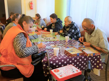 Mieszkańcy grają w gry planszowe przy stołach