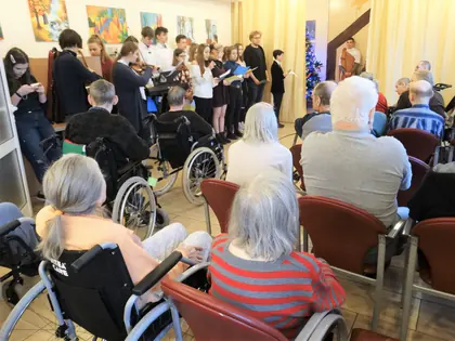 Chór młodzieży śpiewa wśród mieszkańców na wózkach