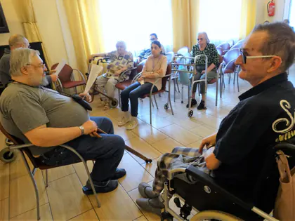 Mieszkańcy siedzą w kręgu podczas spotkania poetyckiego
