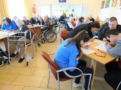 Mieszkańcy i opiekunowie skreślają liczby na kartach bingo