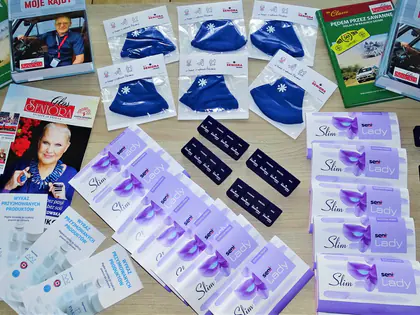 Upominki od stowarzyszenia: maseczki, broszury, książki i saszetki ułożone na stole