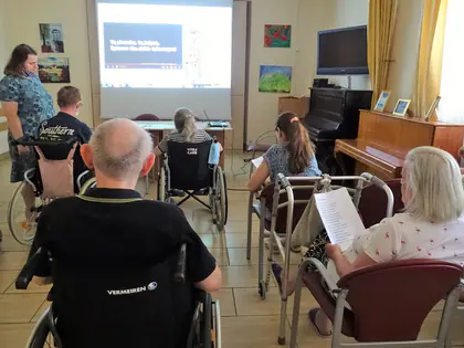 Mieszkańcy oglądają prezentację o Powstaniu Warszawskim w świetlicy