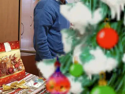 Mieszkaniec przy choince z prezentami