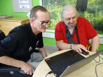 Dwaj mieszkańcy przy laptopie uczą się obsługi komputera