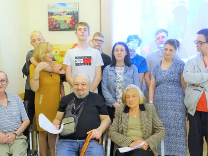 Mieszkańcy i młodzież pozują do wspólnego zdjęcia w świetlicy
