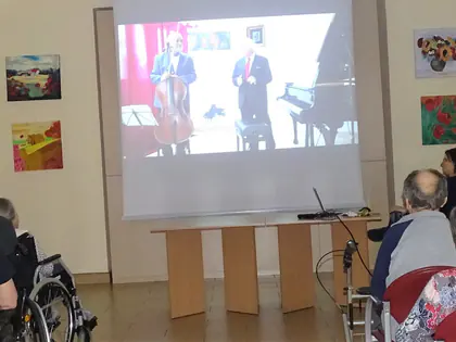 Mieszkańcy oglądają koncert wyświetlany na ekranie