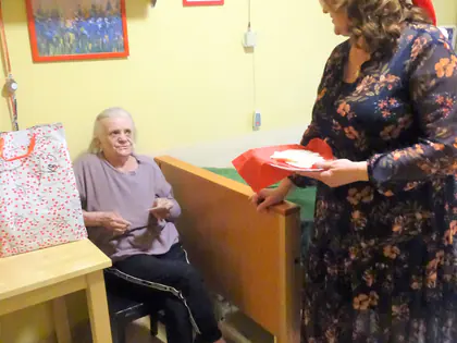 Pracownica w czapce Mikołaja odwiedza mieszkankę w pokoju