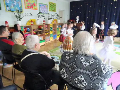 Mieszkańcy oglądają jasełka przedszkolaków w sali przedszkolnej