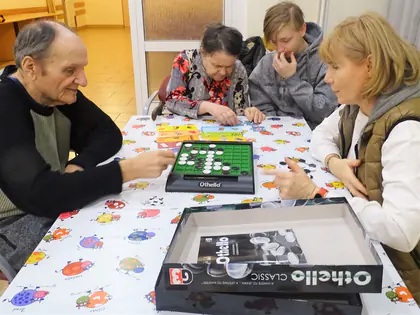 Mieszkańcy i goście grają w Othello przy stole