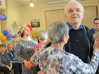 Mieszkanka tańczy z mieszkańcem w świetlicy pełnej balonów
