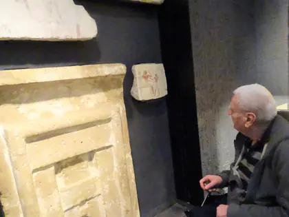 Mieszkaniec przygląda się kamiennemu reliefowi w muzeum