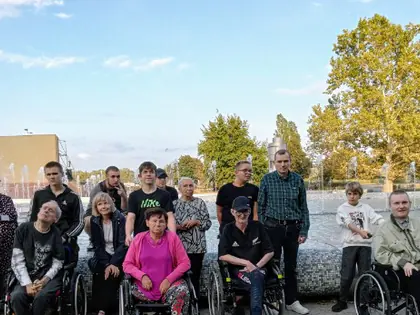 Mieszkańcy i opiekunowie pozują przed fontannami