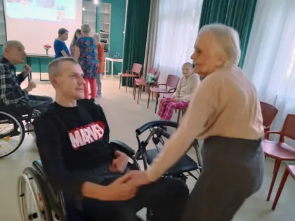 Mieszkanka tańczy z mieszkańcem na wózku