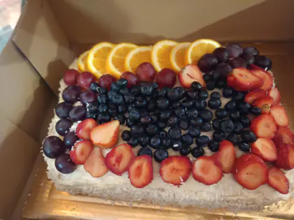 Tort ozdobiony jagodami, truskawkami i plasterkami pomarańczy