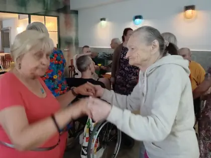Mieszkanki tańczą trzymając się za ręce