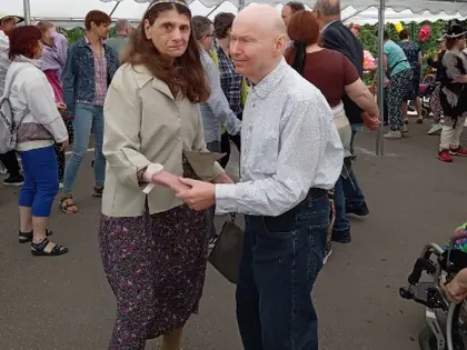 Mieszkanka tańczy z mieszkańcem pod namiotem na festynie
