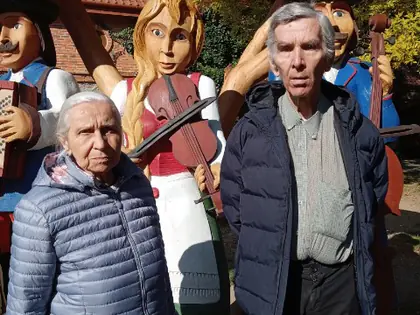 Mieszkańcy pozują przy drewnianych figurach muzykantów