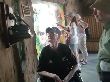 Mieszkaniec na wózku przy wejściu do pawilonu z małpami