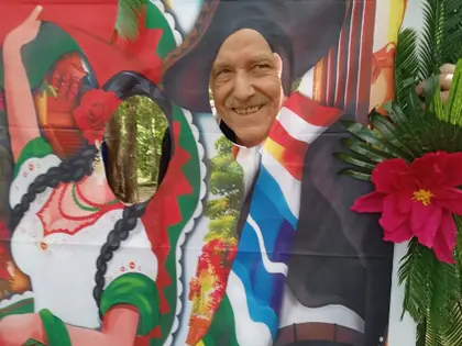 Mężczyzna z twarzą w otworze plakatu z meksykańską tancerką