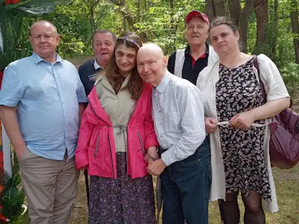 Mieszkańcy i opiekunowie pozują w ogrodzie botanicznym