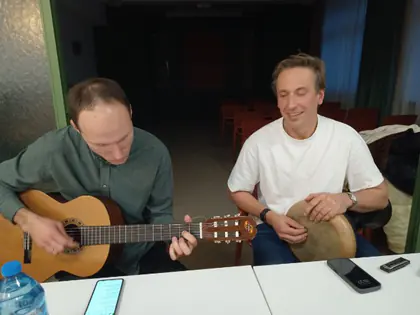Dwaj mężczyźni grają na gitarze i bębenku