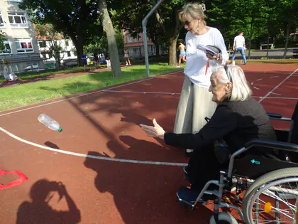 Mieszkanka na wózku rzuca butelkę podczas zabawy na boisku