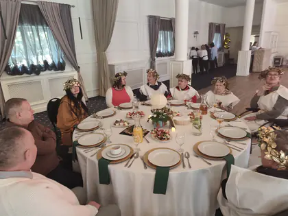 Mieszkańcy w wieńcach laurowych przy okrągłym stole na balu